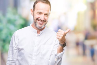 Orta yaş ağarmış komuta sizde seyir ve başparmak yanında yukarıyı mutlu yüz ile gülümseyen izole arka plan üzerinde.