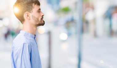 Genç yakışıklı iş adamı izole arka tarafına, seyir üzerinde dinlenmek doğal yüz emin gülümseme ile pozuyla profili.