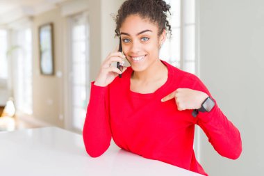 Genç afro-amerikan kadın kendini parmak işaret sürpriz yüzü ile akıllı telefonda konuşurken bir konuşma yapıyor