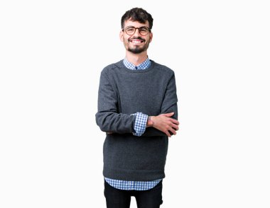 Genç yakışıklı akıllı adam izole arka plan üzerinde gözlük giyiyor mutlu yüz, kamera bakarak çapraz silah ile gülümsüyor. Pozitif kişi.