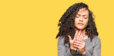 Gri kazak giyen kıvırcık saçlı Genç güzel kadın eller ve parmaklar, artrit iltihabı acı acı