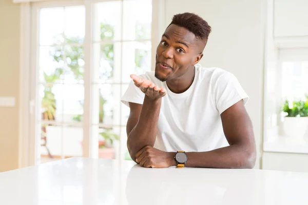 Beau Afro Américain Sur Table Blanche Maison Regardant Caméra Souffler — Photo