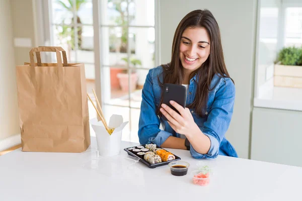 歯を見せる自信に満ちた笑顔で立ち上がり 笑顔でスマートフォンを使ってアプリから食べ物の配達を注文する美しい若い女性 — ストック写真