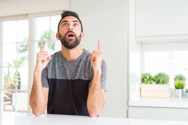 Bonito Homem Hispânico Vestindo Camiseta Casual Casa Espantado Surpreso Olhando — Fotografia de Stock