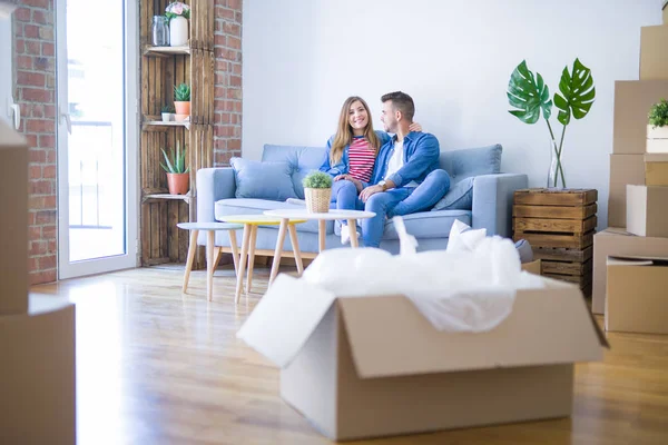 Joven Hermosa Pareja Sentada Abrazándose Sofá Nuevo Apartamento Con Cajas — Foto de Stock