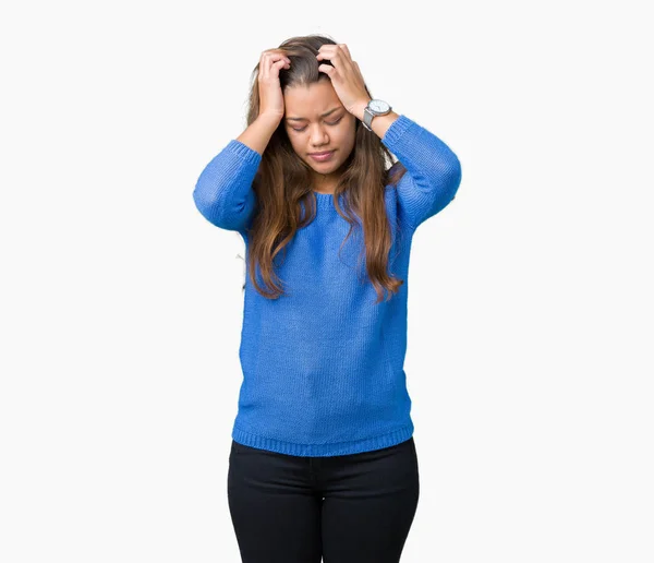 必死と強調した頭痛に苦しんで孤立の背景に青いセーターを着ている若い美しいブルネットの女性の痛みと片頭痛 頭に手 — ストック写真