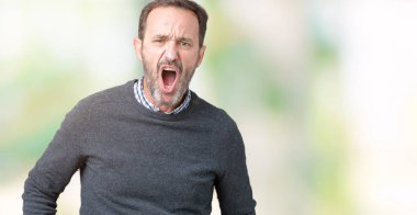 Şüpheci ve alaycı, şok karşısında izole arka plan üzerinde bir Kazak giymiş yakışıklı orta yaş komuta sizde açık ağız ile şaşırttı