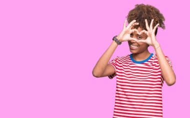 İzole arka plan yaparken kalp şekli ile el ve parmak işareti seyir gülümseyen güzel genç Afro-Amerikan kadın