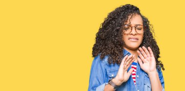 Kıvırcık saçları olan genç güzel kadın gözlük tikdürme ifade, nefret ve korkuya karşı nefreti yüz yapıyor çünkü kaçınma reaksiyon. Ellerle kaldırdı. Rahatsız edici kavramı.