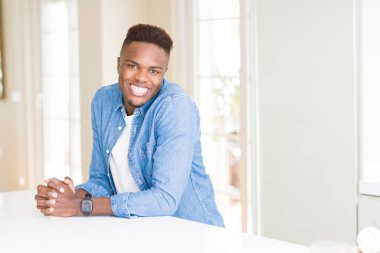 Gülümseyen yüzünde kocaman bir gülümseme ile neşeli Afrika yakışıklı genç