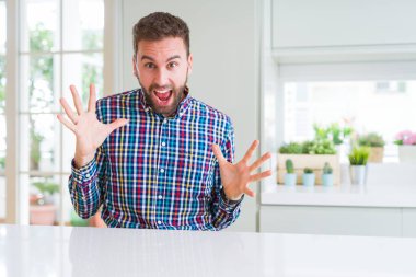 Renkli gömlek giyen yakışıklı adam deli kutluyor ve kollarını kaldırdı ve açık gözleri heyecan çığlık ile başarı için hayran. Kazanan kavramı