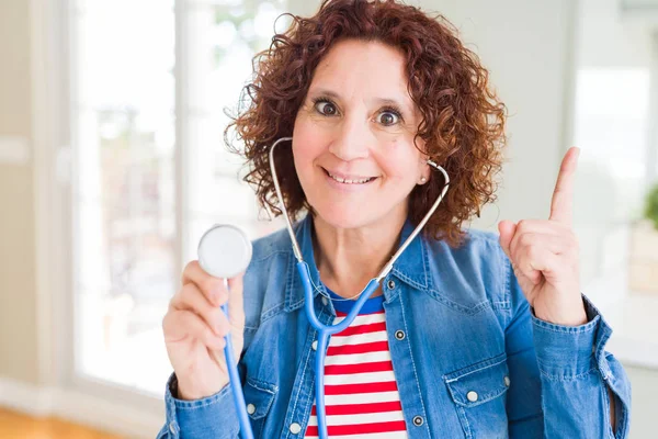聴診器を使って健康をチェックするシニア女性は 幸せな顔で指を指すアイデアや質問に驚き ナンバーワン — ストック写真