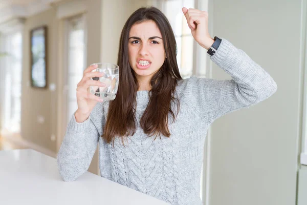 美丽的年轻女子喝一杯新鲜的水恼火和沮丧的喊叫与愤怒 疯狂和大喊大叫与举手 愤怒的概念 — 图库照片