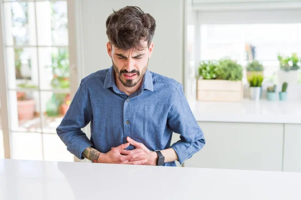 Young Man Wearing Casual Shirt Sitting White Table Hand Stomach — Stock Photo, Image