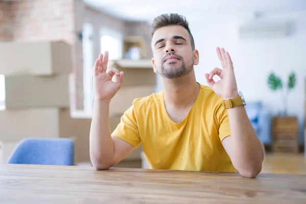 Jovem Sentado Mesa Com Caixas Papelão Atrás Dele Movendo Para — Fotografia de Stock