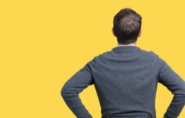 Üzerinde bir kazak giyen yakışıklı orta yaş üst düzey adam arka plan ayakta geriye doğru uzakta silah ile vücut üzerinde seyir izole