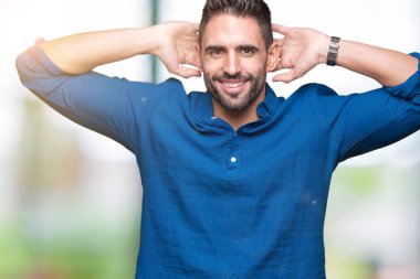 İzole genç yakışıklı adam arka plan dinlenirken ve germe kollar ve eller baş ve boyun arkasında ile mutlu gülümseyerek