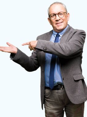 Yakışıklı üst düzey businesss Gözlük adam ve el ile sunulması ve parmak ile işaret ederken hayret ve gülümseyerek kameraya bağla.