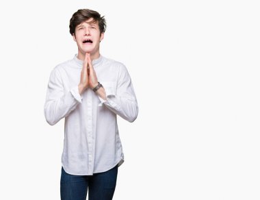 Genç yakışıklı iş adamı yalvarıyor ve umut ifade yüzünde çok duygusal ve endişe ile birlikte elleriyle dua izole arka plan üzerinde. Bağışlanmak. Din kavramı.