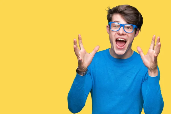 Jonge Knappe Man Blauw Bril Geïsoleerd Achtergrond Vieren Gek Verbaasd — Stockfoto