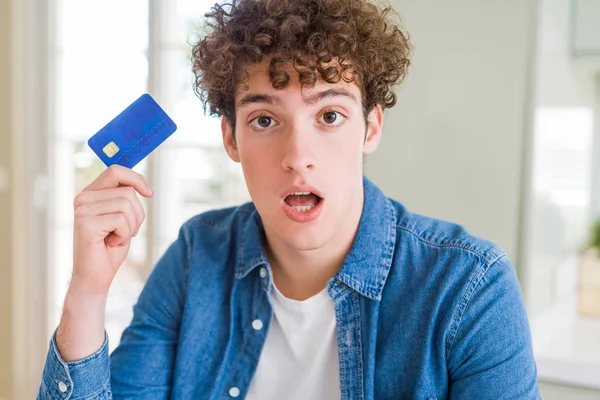Νέος Άνθρωπος Κρατώντας Πιστωτική Κάρτα Φοβισμένη Σοκ Μια Έκπληξη Πρόσωπο — Φωτογραφία Αρχείου