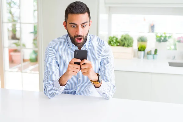 Pohledný Hispánec Který Používá Smartphone Šoku Překvapivý Tváří Vyděšený Vzrušený — Stock fotografie