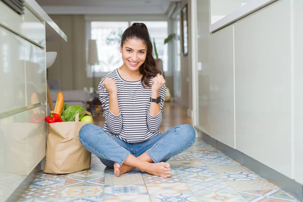 Young Woman Sitting Kitchen Floor Paper Bag Full Fresh Groceries Royalty Free Stock Photos