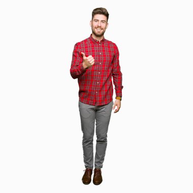 Genç yakışıklı adam el ile jest kadar mutlu thumbs yapıyor. Başarı göstererek kameraya bakarak ifadeyi onaylama.