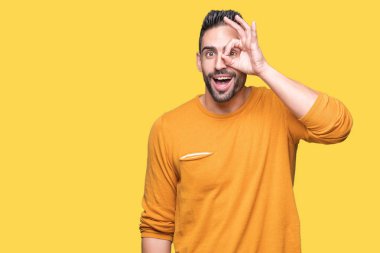 Genç yakışıklı adam gülümsüyor, parmakları ile mutlu yüz üzerinden seyir göz el ile ok jest yapıyor izole arka plan üzerinde.