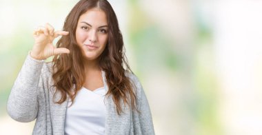 Artı boyutu genç kadın giyiyor kış ceket izole arka plan üzerinde güzel gülümseyen ve boyutu işi el ile kendinden emin eller parmakları ile seyir ve fotoğraf makinesi oturum açın. Ölçü kavramı.