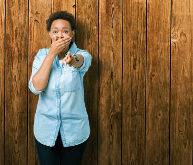 Genç güzel Afrikalı-Amerikalı kadın yüzünden izole arka plan sizin parmak el kamerasıyla ağzına, utanç ifadesi işaret eden gülme