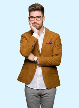 Seyir yorgun ve çapraz kolları olan depresyon sorunları ile sıkılmış düşünme gözlüklü genç yakışıklı iş adamı.