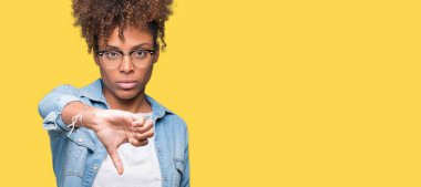 Mutsuz ve kızgın ret gösterilen ve başparmak aşağı hareketi ile negatif seyir izole arka plan üzerinde gözlük güzel genç Afro-Amerikan kadın. Kötü ifade.