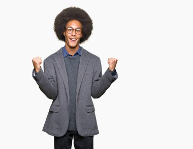 Silah ile şaşırmış ve hayret için başarı kutluyor gözlük takan afro saçlı genç Afro-Amerikan iş adamı kaldırdı ve gözleri açık. Kazanan kavramı.