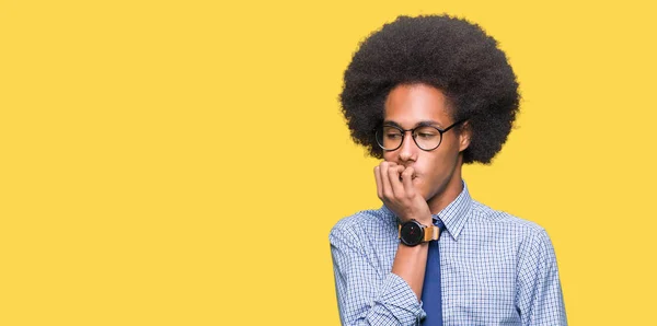 アフロ髪眼鏡を強調し 両手の爪を噛んで口の中で神経を探して若いアフリカ系アメリカ人ビジネスマン不安の問題 — ストック写真