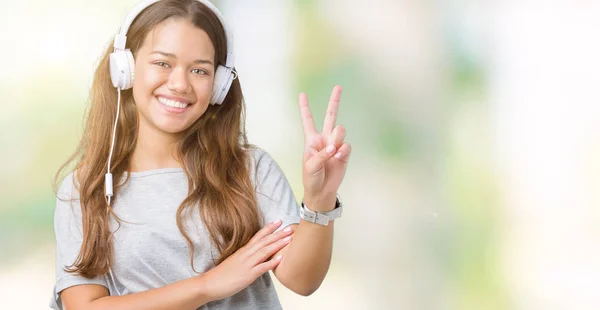Молода Красива Жінка Навушниках Слухає Музику Над Ізольованим Фоном Посміхаючись — стокове фото