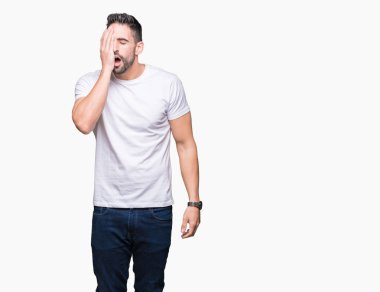 Yakışıklı adam beyaz izole arka plan üzerinde beyaz t-shirt giyen el ile yarım yüz, göz ve ağız kapsayan yorgun esneme. Yüz acı içinde acıyor.