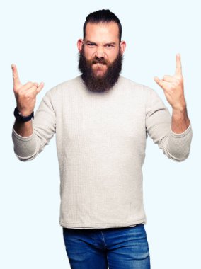 Genç sarışın adam el yukarı ile kaya sembolü yapıyor çılgın ifade bağırarak rahat kazak giyiyor. Müzik yıldızı. Ağır kavram.