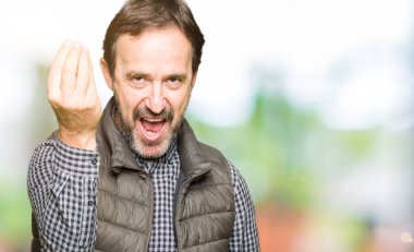 Orta Çağ yakışıklı adam kış yelek giyiyor el ve parmaklar ile Italyan jest yapıyor emin ifade