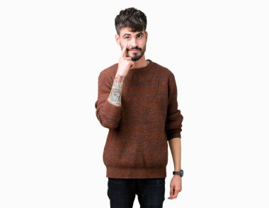 Genç yakışıklı adam giyen kış kazak izole arka plan üzerinde göz izlerken seni jest için şüpheli ifade işaret