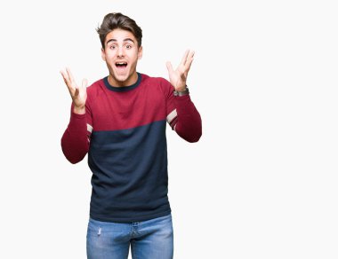 Yakışıklı delikanlı deli kutluyor ve silah ile başarı için heyecanlı çığlık kaldırdı ve açık gözleri hayret izole arka plan üzerinde. Kazanan kavramı