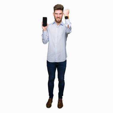 Genç yakışıklı adam iş gösteren smartphone ekran ile öfke, çılgın ve yükseltilmiş eliyle diye bağıran rahatsız ve hayal kırıklığına uğramış öfke kavramı bağırarak