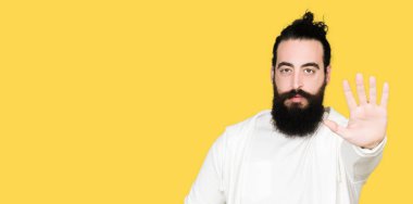Uzun saç ve sakal stop yapıyor sportif sweatshirt giyen genç adamla elin avuç ile şarkı. Negatif ve ciddi bir jest yüz ifadesiyle uyarı.