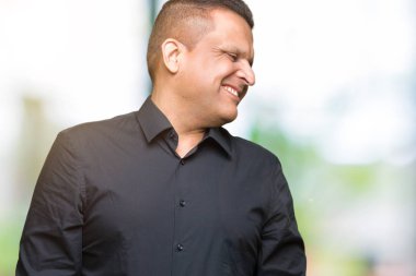 Yakışıklı orta yaş Arap iş adamı uzak tarafına yüzünde, doğal ifade gülümseme ile seyir izole arka plan üzerinde. Kendine güvenen gülüyor.