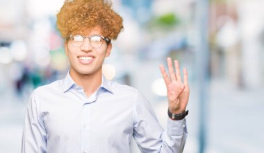 Genç yakışıklı iş adamı gösterilen ve parmakları ile işaret afro gözlük ile kendinden emin ve mutlu gülümseyerek süre dört numara.