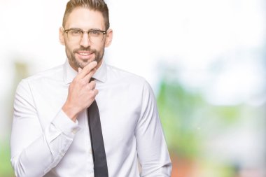 Emin çapraz kollar ve çeneme kaldırdı el ile gülümseme ile kameraya bakarak izole arka plan üzerinde gözlük takan genç yakışıklı iş adamı. Pozitif düşünce.