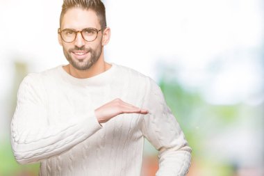 Büyük ve büyük boy işaret, ölçü birimi sembol gösteren ellerle eller izole arka plan üzerinde gözlük takan yakışıklı delikanlı. Kameraya bakarak gülümsüyordu. Ölçüm kavramı.