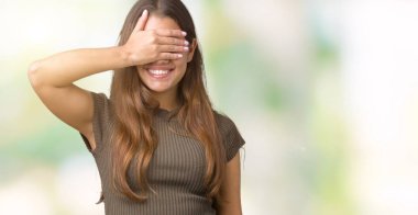 Genç güzel esmer kadın gülümsüyor ve gözleri için sürpriz kapsayan yüz el ile gülüyor izole arka plan yüzünden. Kör kavramı.