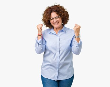 Güzel orta ager üst düzey businees kadın üzerinde gözlük gülümseyen ve başarı için çığlık arka plan çok mutlu ve heyecanlı kaldırdı, silah ile kazanan jest yapıyor izole. Kutlama kavramı.