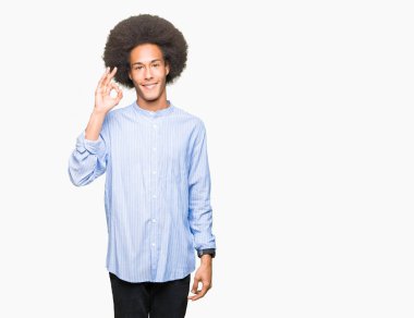Afro saç gülümseyen genç Afro-Amerikan adam el ve parmaklar ok işaretiyle yapıyor olumlu. Başarılı ifade.